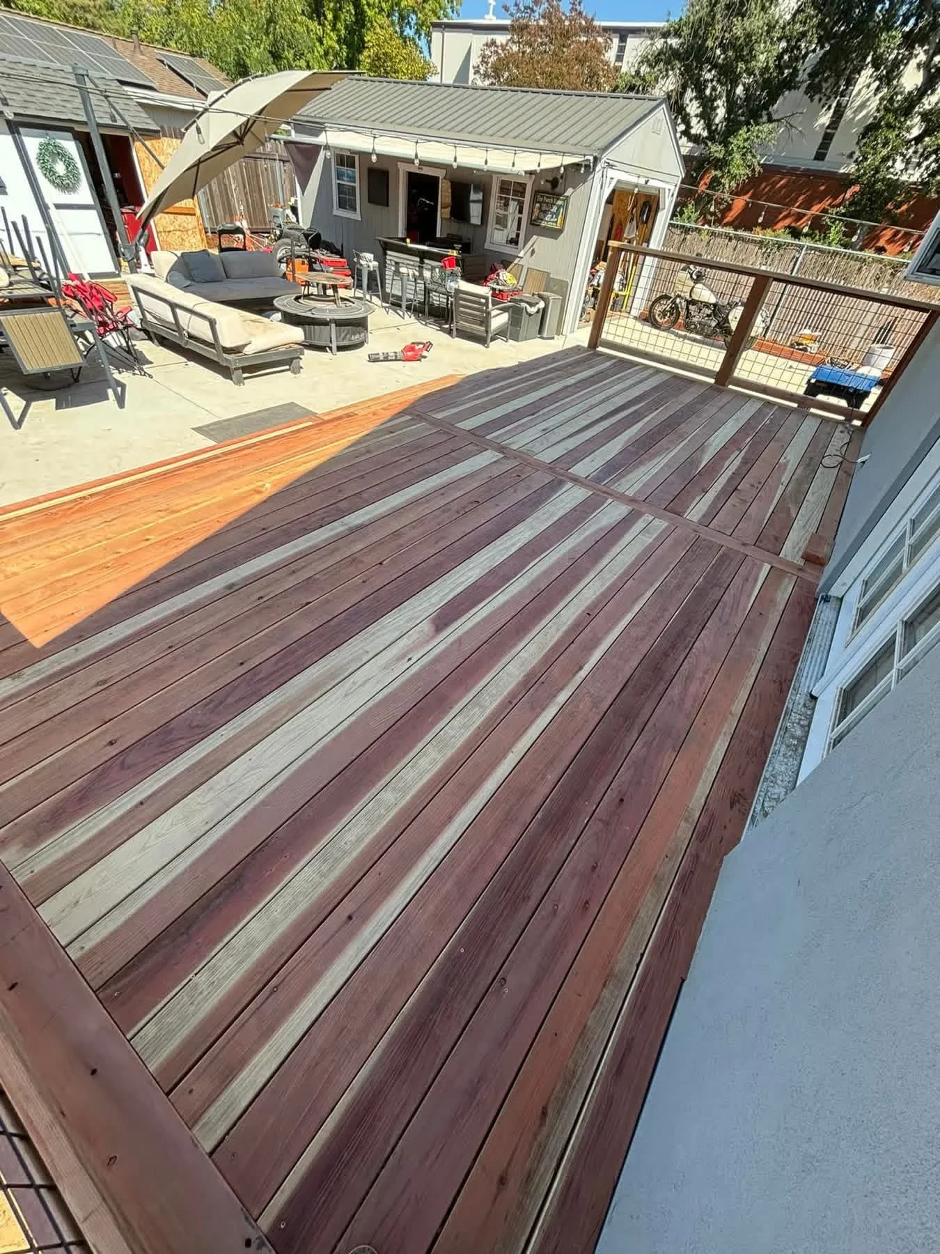 Composite deck with alternating dark brown and gray boards, linear pattern, metal railing