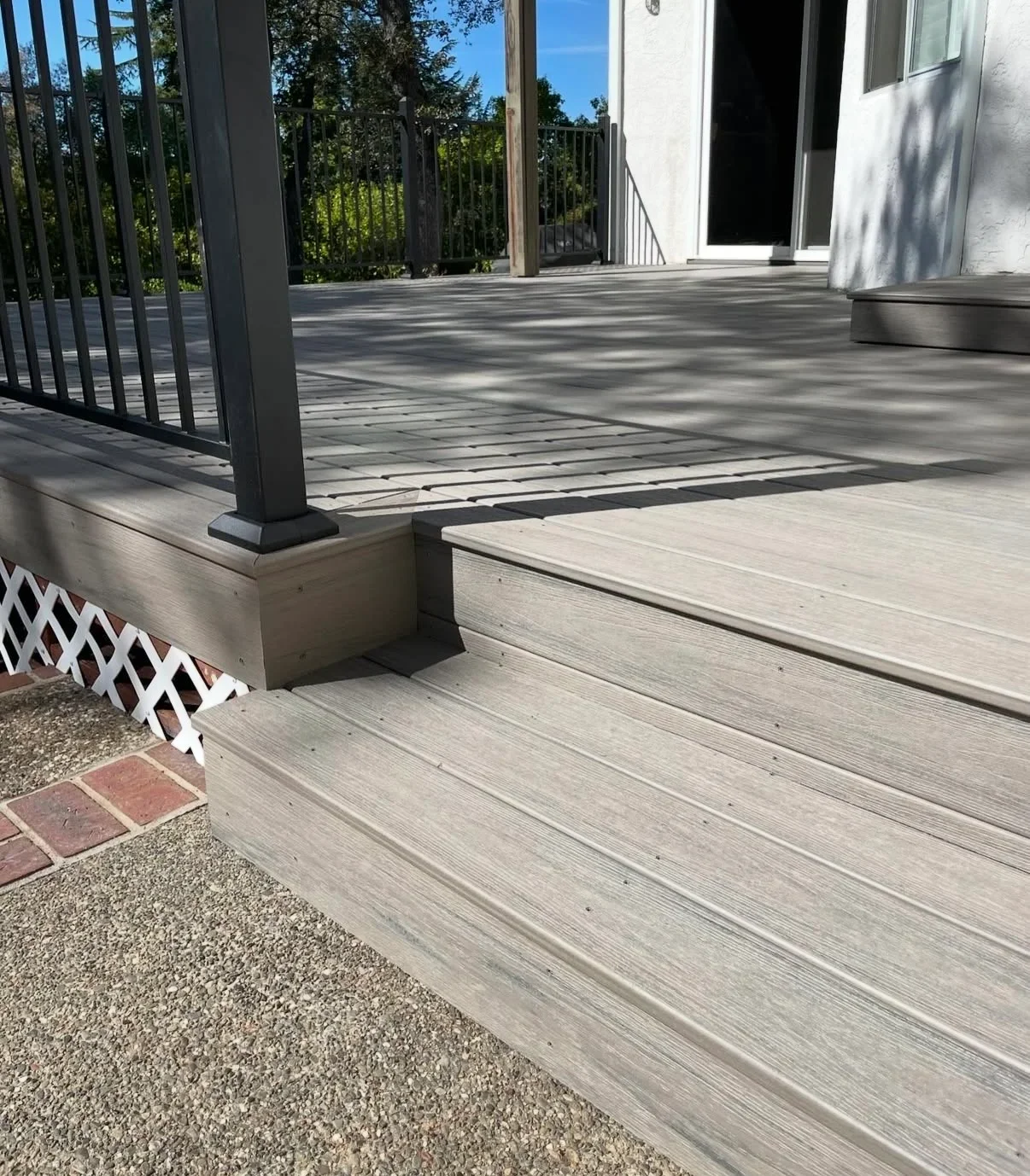 Gray composite deck with black metal railing, planter box, and multi-level construction